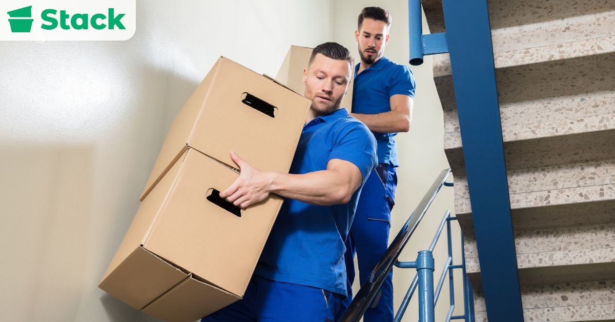 Movers loading labelled boxes, illustrating whether moving companies provide boxes