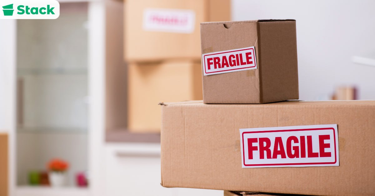 Stacked cardboard moving boxes marked with red FRAGILE labels, showing how labeling every container keeps packing organized