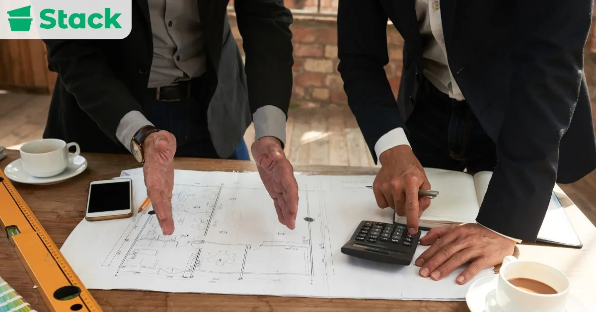 Business professionals reviewing floor plans and calculating costs while setting a moving budget and timeline 3–6 months before moving day.
