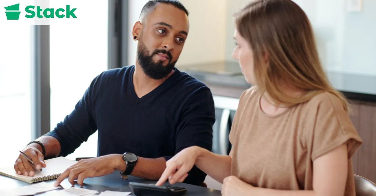 Two professionals discussing and planning an office move while reviewing documents and timelines during the early pre-move planning stage.
