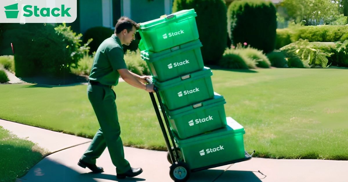 How to Choose Packing and Storage Containers for a Move Mover pushing a hand truck loaded with green Stack plastic moving bins